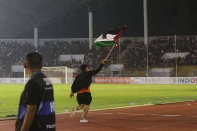 Salah seorang penonton mengibarkan bendera Palestina ke lapangan usai pertandingan Persiraja vs Semen Padang FC di Stadion Harapan Bangsa Banda Aceh, Sabtu malam (21/10/2023). Foto: HO/Hendri/Antara