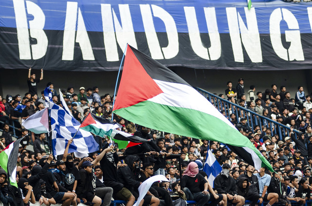 Pendukung Persib Bandung (Bobotoh) membentangkan bendera Palestina saat menonton laga Liga 1 di Stadion Gelora Bandung Lautan Api, Bandung, Jawa Barat, Rabu (8/11/2023). Foto: Novrian Arbi/Antara Foto