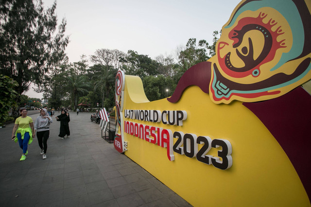 Warga berjalan di depan dekorasi instalasi bertema Piala Dunia U-17 di kawasan Stadion Manahan, Solo, Jawa Tengah, Rabu (8/11/2023). Foto: Mohammad Ayudha/Antara Foto