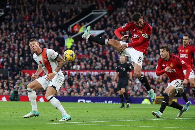 Pemain Luton Town Ross Barkley beraksi dengan pemain Manchester United Bruno Fernandes di Old Trafford, Manchester, Inggris, Sabtu (11/11/2023). Foto: Phil Noble/REUTERS
