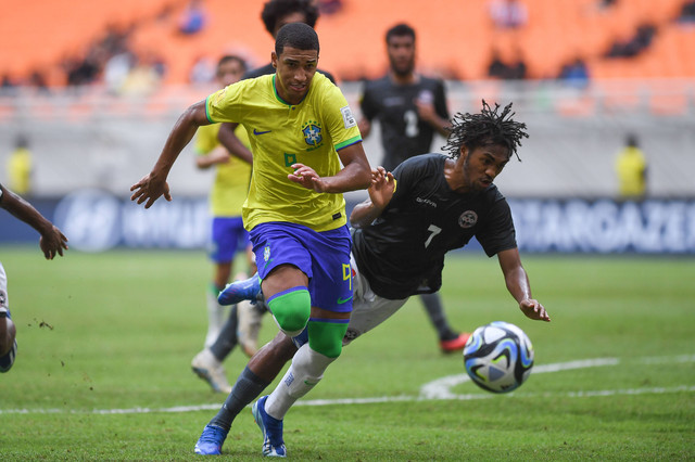 Pesepak bola Timnas Brazil Kaua Elias (kiri) berebut bola dengan pesepak bola Timnas Kaledonia Baru Bayron Gohoupe dalam penyisihan Grup C Piala Dunia U-17 di Jakarta International Stadium, Jakarta, Selasa (14/11/2023). Foto: Sigid Kurniawan/ANTARA FOTO
