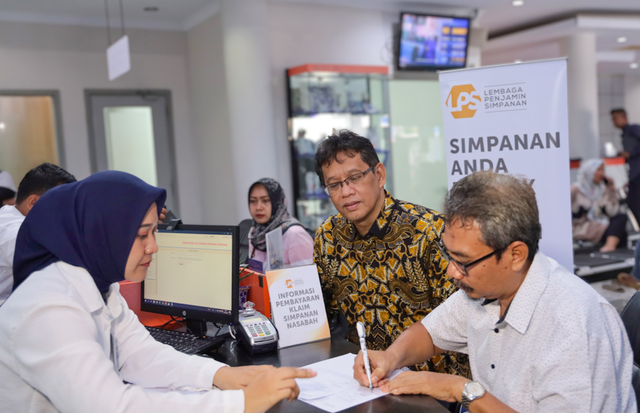 Nasabah BPR Karya Remaja Indramayu (Kanan) menandatangani bukti pencairan dana simpanannya yang dibayarkan oleh LPS, disaksikan Ketua Dewan Komisioner LPS Purbaya Yudhi Sadewa. Foto: Dok. LPS