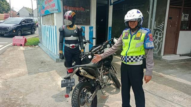 Seorang pria yang berkostum Ksatria Baja Hitam kena tilang saat melintas di Perempatan Kentungan, Kapanewon Depok, Kabupaten Sleman, Selasa (14/11). Foto: Dok Satlantas Polresta Sleman