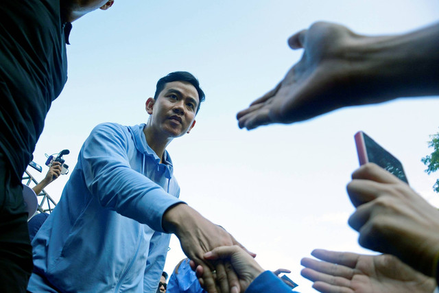 Calon Wakil Presiden nomor urut 2 Gibran Rakabuming Raka menyalami peserta Jalan Sehat Satu Putaran di Jalan Jenderal Sudirman, Makassar, Sulawesi Selatan, Sabtu (25/11/2023). Foto: Hasrul Said/ANTARA FOTO