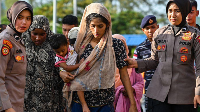 Pengungsi Rohingya menaiki kapal feri di sebuah pantai di pulau Sabang, provinsi Aceh, Indonesia pada Rabu (22/11), saat mereka direlokasi oleh aparat keamanan.