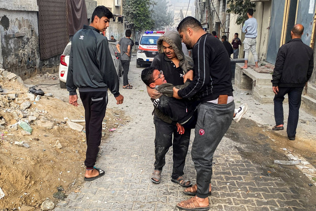 Warga Palestina membawa seorang anak laki-laki yang terluka menyusul serangan Israel di sebuah rumah, setelah gencatan senjata sementara antara Hamas dan Israel berakhir, di Rafah, di selatan Jalur Gaza, Jumat (1/12/2023). Foto: Hatem Khaled/REUTERS