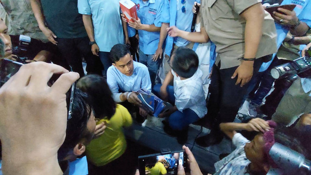 Cawapres nomor urut 2 Gibran Rakabuming Raka membagikan buku kepada anak-anak saat kampanye di Penjaringan, Jakut, Senin (1/12/2023). Foto: Fachrul Irwinsyah/kumparan