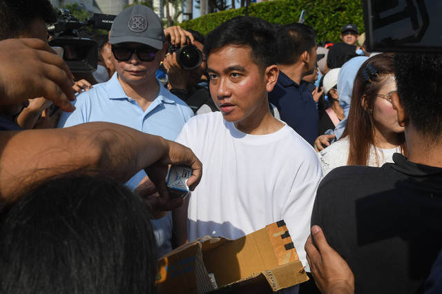 Cawapres nomor urut 2 Gibran Rakabuming Raka (tengah) membagikan susu kemasan ke warga di area hari bebas kendaraan bermotor (HBKB) Jalan MH Thamrin, Jakarta, Minggu (3/12/2023). Foto: Aditya Pradana Putra/Antara Foto