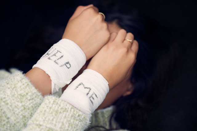 Woman, depression and wrist with help on bandage for suicide, self harm or person in dark mental health crisis. Bandages, girl and injury from depressed accident, problem or mistake in cutting wrists. Foto: Shutterstock