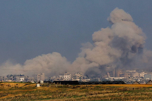 Asap mengepul di antara bangunan-bangunan yang hancur akibat serangan Israel, di tengah konflik yang sedang berlangsung antara Israel dan kelompok Islam Palestina Hamas, terlihat dari Israel selatan, Rabu (6/12/2023). Foto: Athit Perawongmetha/REUTERS
