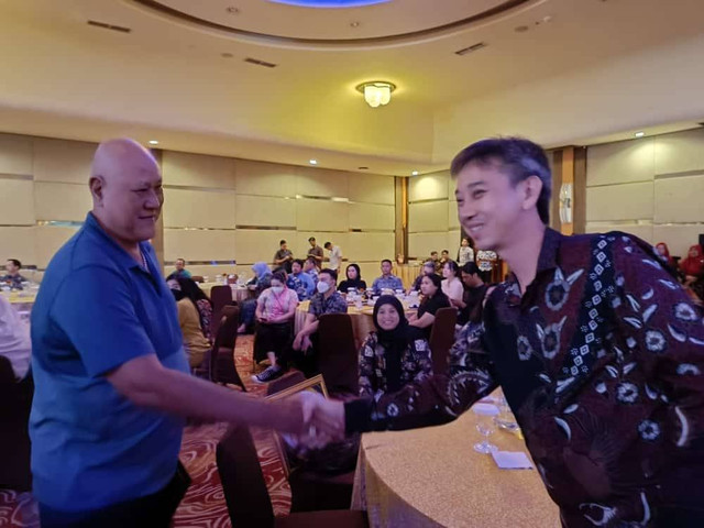 Dua legenda warung kopi di Pontianak, Asiang (kanan) dan Limin alias Aming (kiri), bersalaman saat keduanya bertemu di Pajak Award yang digelar Badan Keuangan Daerah Kota Pontianak, Jumat malam, 8 Desember 2023. Foto: Jimmy Ibrahim/Prokopim Pemkot Pontianak