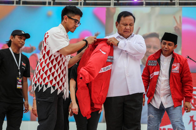 Ketum PSI Kaesang Pangarep (kiri) memasangkan jaket PSI kepada Ketum Partai Gerindra yang juga calon presiden nomor urut 2 Prabowo Subianto pada puncak perayaan HUT ke-9 PSI di Stadion Jatidiri, Semarang, Jawa Tengah, Sabtu (9/12/2023). Foto: Makna Zaezar/ANTARA FOTO