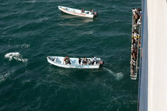 Orang-orang berjalan menuruni tangga dari kapal komersial Galaxy Leader, yang disita oleh Houthi di lepas pantai al-Salif, Yaman. Foto: Khaled Abdullah/REUTERS