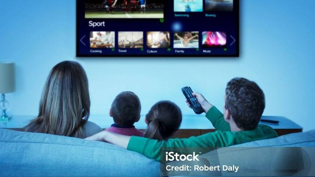 Keluarga sedang menonton televisi di ruang keluarga. Foto : iStock