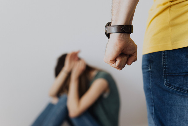 Gambar : Kekerasan dalam toxic relationship (Sumber : https://www.pexels.com/photo/man-clenching-fist-near-a-woman-covering-face-while-sitting-4379912/)