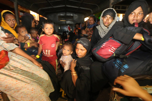 Imigran etnik Rohingya asal Myanmar menaiki kendaraan menuju tempat penampungan sementara di Banda Aceh, Aceh, Minggu (10/12/2023) malam. Foto: ANTARA FOTO/Irwansyah Putra