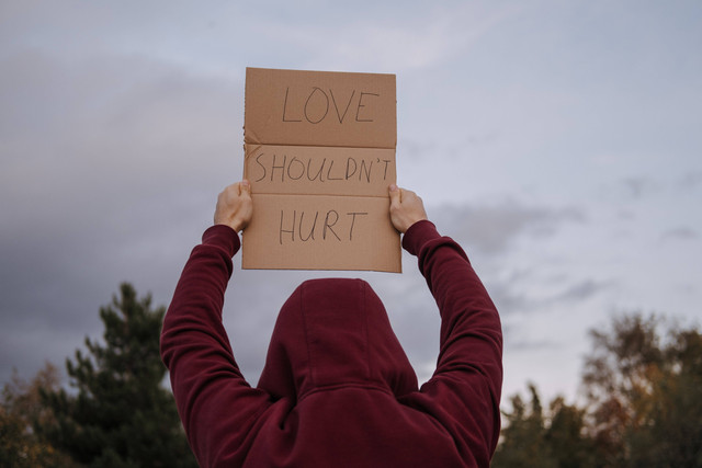 Gambar : Cinta tak seharusnya menyakitkan (Sumber : https://www.pexels.com/photo/anonymous-activist-showing-placard-with-anti-violence-inscription-5723325/)