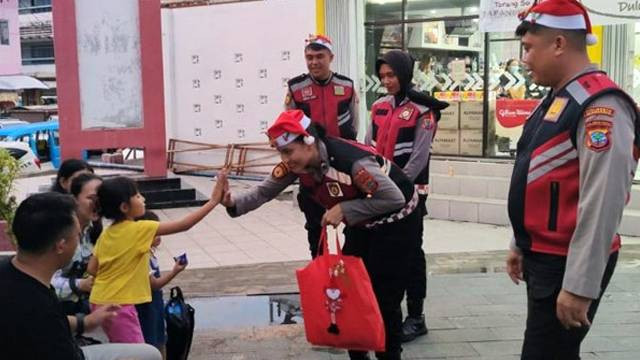 Personel kepolisian di Manado menggunakan topi santa claus saat melakukan patroli. (foto: dokumen istimewa)