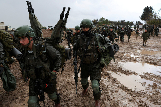 Tentara Israel bersiap memasuki Jalur Gaza, di tengah konflik yang sedang berlangsung antara Israel dan kelompok Islam Palestina Hamas, di perbatasan Israel dengan Gaza di Israel selatan, 13 Desember 2023. Foto: Ronen Zvulun/Reuters