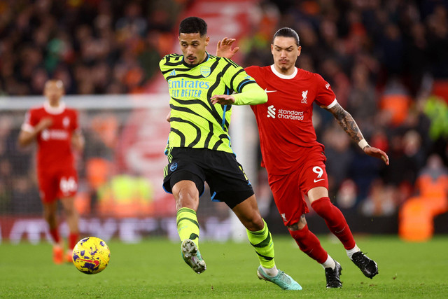 Pemain Liverpool Darwin Nunez berebut bola dengan pemain Arsenal William Saliba pada pertandingan Liga Inggris di Anfield, Liverpool, Inggris, Minggu (24/12/2023). Foto: Carl Recine/REUTERS
