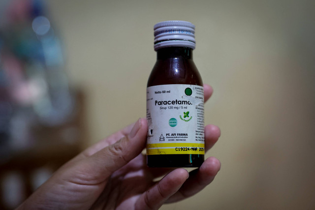 Menujukkan obat: Desi Permatasari, menunjukkan sebotol sirup Afi Farma di rumahnya di Bogor, Jawa Barat. Foto: Willy Kurniawan/REUTERS