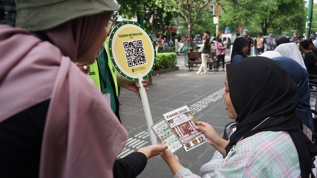 Seorang wisatawan di Malioboro sedang bertanya di pos pelayanan indormasi wisatawan di Malioboro, Selasa (26/12). Foto: Arif UT/Pandangan Jogja