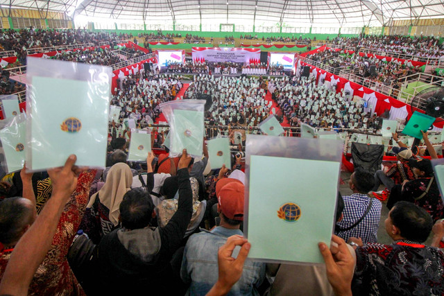 Warga menunjukkan sertifikat tanah saat acara penyerahan sertifikat tanah untuk rakyat Jawa Timur di Gelora Delta Sidoarjo, Jawa Timur, Rabu (27/12/2023). Foto: Umarul Faruq/ANTARA FOTO