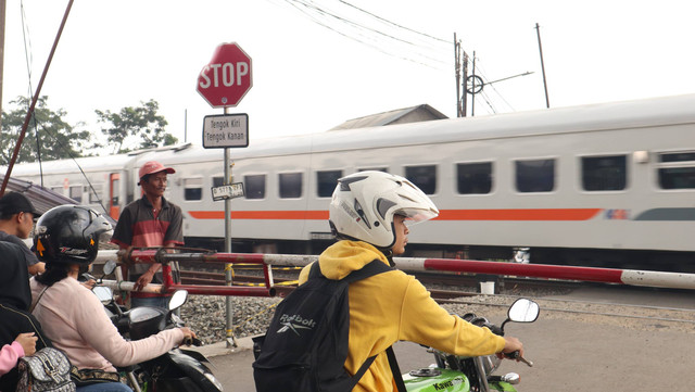 Aktivitas salah satu perlintasan KA sebidang  di Desa Cisaranten Endah, Kota Bandung  yang dikelola masyarakat (Foto: Izzuddin Hamid).