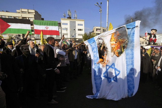 Warga Iran membakar bendera Israel saat protes di Teheran untuk mendukung warga Palestina di Gaza pada 18 November 2023. Foto: AFP