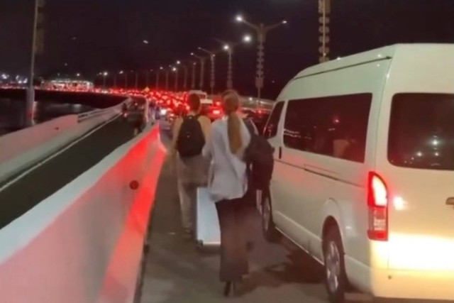 Wisatawan berjalan kaki dari tol menuju Bandara Internasional I Gusti Ngurah Rai mengejar jadwal penerbangan, akibat kemacetan parah di Taman Bundaran Bandara Ngurah Rai, Bali, Jumat (29/12/2023). Foto: Instagram/@infodenpasar