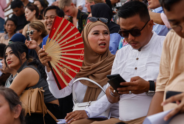 Suasana penonton di teater tari Kecak saat menikmati pertunjukan pergelaran pertunjukan tari "Titi Situbanda" di Pantai Melasti, Bali, 28 Desember 2023. Foto: David Gannon / AFP