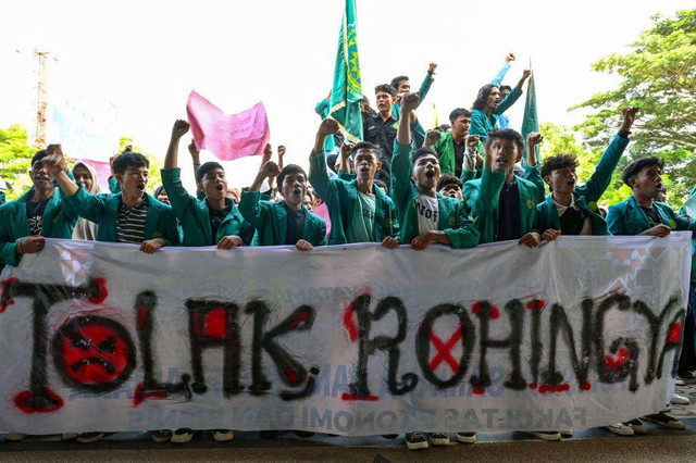Sejumlah mahasiswa memegang spanduk bertuliskan “Tolak Rohingya” saat berdemonstrasi menentang kedatangan pengungsi Rohingya di depan gedung DPR Acehdi Banda Aceh, 27 Desember 2023.