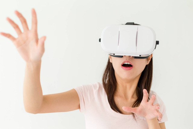 Ilustrasi perempuan bermain di Metaverse menggunakan kacamata VR. Foto: leungchopan/Shutterstock