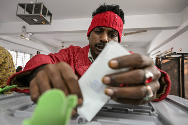 Seorang pria memberikan suara dalam pemilihan umum Bangladesh di Dhaka pada 7 Januari 2024. Foto: INDRANIL MUKHERJEE / AFP