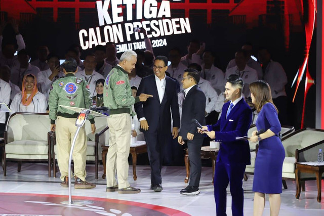 Calon presiden nomor urut 03 Ganjar Pranowo berbincang dengan cawapres nomor 01 Muhaimin Iskandar saat debat ketiga Pilpres 2024 di Istora Senayan, Kompleks GBK, Jakarta Pusat, Minggu (7/1/2024). Foto: Iqbal Firdaus/kumparan
