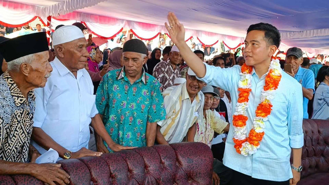 Cawapres Gibran Rakabuming Raka dan istrinya, Selvi Ananda saat bagi-bagi susu di Lapangan Desa Liang, Salahutu, Maluku Tengah, Maluku, Senin (8/1). Foto: Zamachsyari/kumparan
