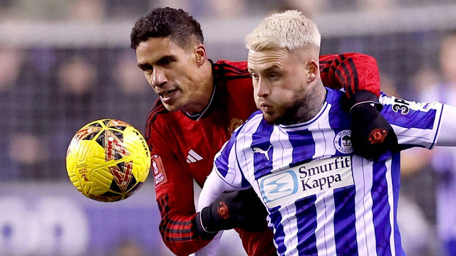 Raphael Varane duel dengan Stephen Humphrys saat Wigan Athletic vs Manchester United (MU) dalam laga Piala FA 2023/24 di Stadion DW pada Selasa (9/1) dini hari WIB. Foto: Action Images via Reuters/Jason Cairnduff