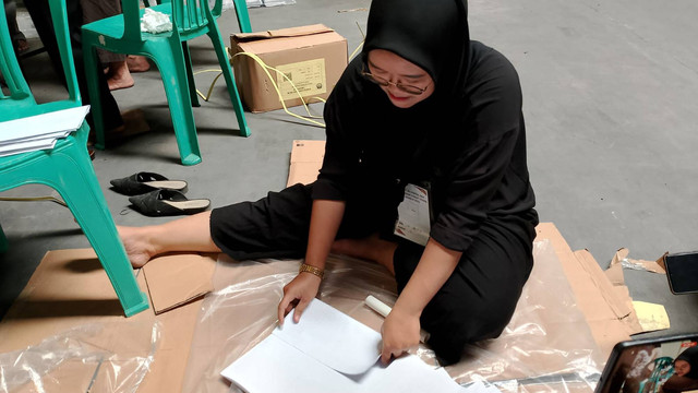 Petugas sortir dan melipat surat suara Pemilu 2024 di Bekasi. Foto: kumparan