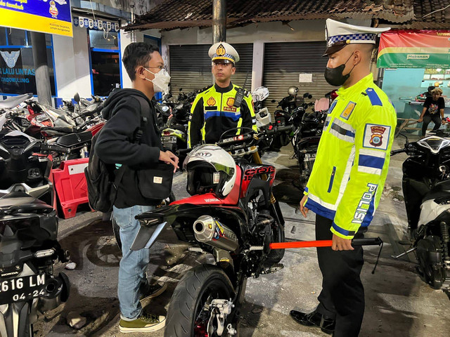 Polisi menilang pengendara sepeda motor yang mengenakan knalpot brong. Foto: Dok. Polres Bantul