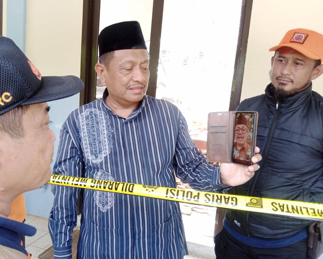 Kepala Dinas Pendidikan (Disdik) Kabupaten Cirebon, Jawa Barat, Ronianto, saat menerima panggilan video dari Bupati Cirebon, Imron, saat meninjau atap bangunan SMPN 2 Greged yang ambruk. Foto: Tarjoni/Ciremaitoday
