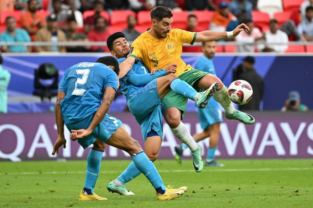 Bruno Fornaroli (kanan) melepaskan tembakan dalam pertandingan Grup B Piala Asia 2023 antara Australia vs India di Stadion Ahmad bin Ali, Al Rayyan, Qatar, pada Sabtu (13/1). Foto: Hector Retamal / AFP