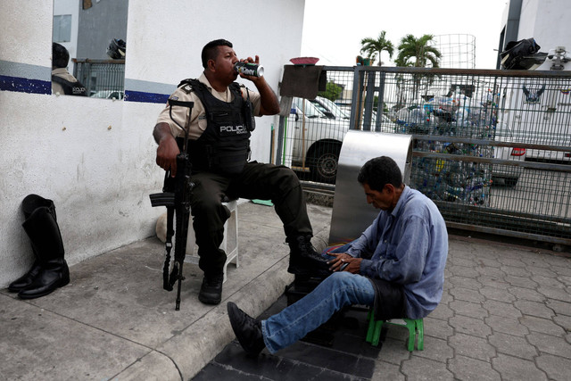 Petugas polisi memeriksa orang-orang, di tengah gelombang kekerasan yang sedang berlangsung di seluruh negara, di Guayaquil, Ekuador, Jumat (12/1/2024). Foto: Ivan Alvarado/REUTERS