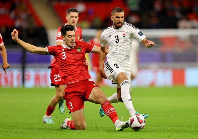 Hussein Ali dari Irak duel dengan Elkan Baggott dari Indonesia saat pertandingan Piala Asia AFC Grup D di Stadion Ahmad bin Ali, Al Rayyan, Qatar. Foto: Ibraheem Al Omari/Reuters