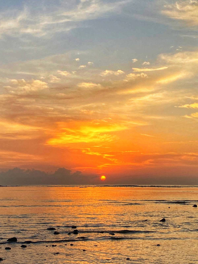 Sunset di Pantai Ayah, Kebumen. Jingga merona bak lukisan alam di negeri dongeng. Menyala tanpa ragu, seolah tahu banyak insan tengan menanti (Photo by Oktavian Aristina).