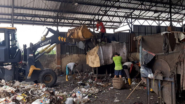 Para pekerja TPA BLE Banyumas sedang memilah sampah menggunakan mesin pemilah. (08/01/2024)