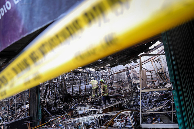 Petugas pemadam kebakaran menyelesaikan proses pendinginan lokasi kebakaran di salah satu ruko di Pasar Mobil, Kemayoran, Jakarta, Rabu (24/1/2024). Foto: Iqbal Firdaus/kumparan
