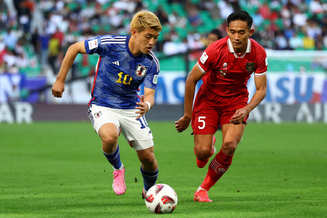 Pemain Timnas Indonesia Rizky Ridho berebut bola dengan pemain Timnas Jepang Ritsu Doan pada pertandingan Grup D Piala Asia 2023 di Stadion Al Thumama, Doha, Qatar, Rabu (24/1/2024). Foto: Molly Darlington/REUTERS