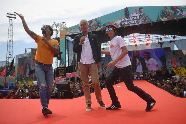 Calon presiden nomor urut 3 Ganjar Pranowo (tengah) bernyanyi dengan personel Slank Kaka (kiri) dan Bimbim (kanan) saat mengikuti kampanye terbuka bertajuk Hajatan Rakyat di Stadion Bima, Cirebon, Jawa Barat, Sabtu (27/1/2024). Foto: Akbar Nugroho Gumay/ANTARA FOTO
