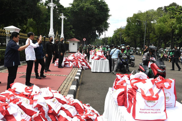 Presiden Joko Widodo menyaksikan penyerahan bantuan paket sembako bagi para pengemudi ojek daring atau ojol di sekitar Kompleks Istana Kepresidenan, Jakarta, pada Kamis, 13 April 2023. Foto: Kris/Biro Pers Sekretariat Presiden
