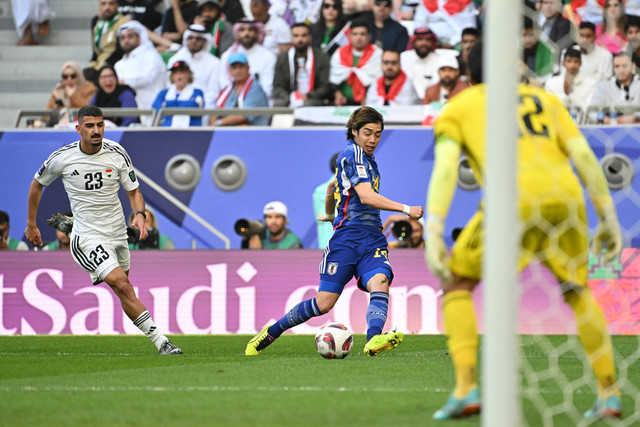 Gelandang Jepang Junya Ito melewati bek Irak Merchas Doski selama pertandingan sepak bola Grup D Piala Asia AFC Qatar 2023 antara Irak dan Jepang di Stadion Kota Pendidikan di Al-Rayyan, sebelah barat Doha pada (19/1/ 2024). Foto: Hector Retamal / AFP